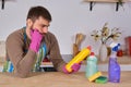 Young man wanted to help his wife in housecleaning, but he doesn`t know what to do with all of detergents