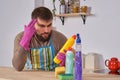 Young man wanted to help his wife in housecleaning, but he doesn`t know what to do with all of detergents