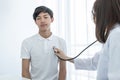 A young man was examined by a female doctor with a stethoscope on his chest Royalty Free Stock Photo