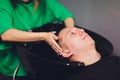 Young man washes his head in a hairdressing salon. Royalty Free Stock Photo