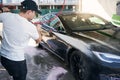 Young man washing car with high pressure washer Royalty Free Stock Photo