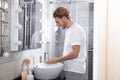 Young man washing hands in bathroom Royalty Free Stock Photo