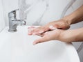 Young man washing hands over sink in bathroom, closeup, Corona virus or Covid-19 prevention, hygiene to stop. Royalty Free Stock Photo