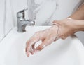 Young man washing hands over sink in bathroom, closeup, Corona virus or Covid-19 prevention, hygiene to stop. Royalty Free Stock Photo