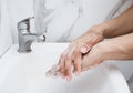 Young man washing hands over sink in bathroom, closeup, Corona virus or Covid-19 prevention, hygiene to stop. Royalty Free Stock Photo