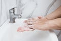 Young man washing hands over sink in bathroom, closeup, Corona virus or Covid-19 prevention, hygiene to stop. Royalty Free Stock Photo