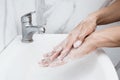 Young man washing hands over sink in bathroom, closeup, Corona virus or Covid-19 prevention, hygiene to stop. Royalty Free Stock Photo