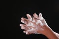 young man washing hands with soap warm water