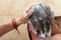 young man washing head hair with shampoo in the shower, male personal hygiene bathroom routine, self skin care, scalp treatment Royalty Free Stock Photo