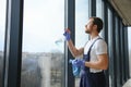 Young man washing window in office Royalty Free Stock Photo