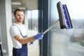 Young man washing window in office Royalty Free Stock Photo