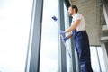 Young man washing window in office Royalty Free Stock Photo