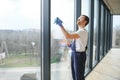 Young man washing window in office Royalty Free Stock Photo