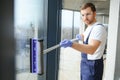 Young man washing window in office Royalty Free Stock Photo