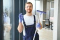 Young man washing window in office Royalty Free Stock Photo