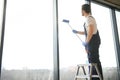 Young man washing window in office Royalty Free Stock Photo