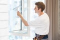 Young man washing window in office Royalty Free Stock Photo