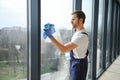 Young man washing window in office Royalty Free Stock Photo