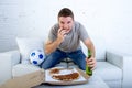 Young man watching football game on television nervous and excited suffering stress biting fingernail on sofa Royalty Free Stock Photo