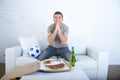 Young man watching football game on television nervous and excited suffering stress praying god for goal Royalty Free Stock Photo