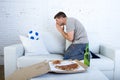 Young man watching football game on television nervous and excited suffering stress praying god for goal Royalty Free Stock Photo