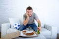 Young man watching football game on television nervous and excited suffering stress on sofa couch Royalty Free Stock Photo