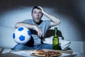 Young man watching football game on tv nervous and excited suffering stress on couch Royalty Free Stock Photo