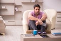 Young man watching tv at home during pandemic Royalty Free Stock Photo