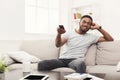 Young man watching tv using remote controller in living room Royalty Free Stock Photo