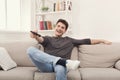 Young man watching tv using remote controller Royalty Free Stock Photo