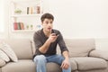 Young man watching tv using remote controller Royalty Free Stock Photo