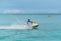 Young Man on water scooter in tropical Valley Church Beach at Caribbean Sea, Antigua