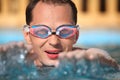 Young man in watersport goggles swimming in pool