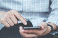 Ã Â¹ÂYoung man wear plaid shirt. close up hand using on cell phone during rest on sofa. Royalty Free Stock Photo