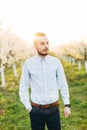 Young man weared in smart casual suit outdoors in his wedding day on background of spring blooming garden. Groom Royalty Free Stock Photo