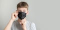 Young man wearing a black surgical mask to protect against the virus Royalty Free Stock Photo