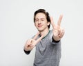 Young man wearing casua shirt smiling looking to the camera showing fingers doing victory sign