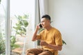 Young man wearing casual clothes talking on a mobile phone in the morning at a window Royalty Free Stock Photo