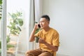 Young man wearing casual clothes talking on a mobile phone in the morning at a window Royalty Free Stock Photo
