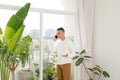 Young man wearing casual clothes talking on a mobile phone in the morning at a window Royalty Free Stock Photo