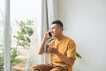 Young man wearing casual clothes talking on a mobile phone in the morning at a window Royalty Free Stock Photo