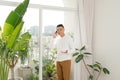 Young man wearing casual clothes talking on a mobile phone in the morning at a window Royalty Free Stock Photo