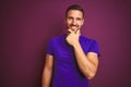 Young man wearing casual purple t-shirt over lilac isolated background looking confident at the camera smiling with crossed arms Royalty Free Stock Photo