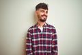 Young man wearing casual shirt standing over isolated white background looking away to side with smile on face, natural expression Royalty Free Stock Photo