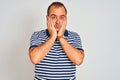 Young man wearing casual striped polo standing over isolated white background Tired hands covering face, depression and sadness, Royalty Free Stock Photo