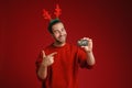 Young man wearing Christmas deer horns pointing finger at credit card Royalty Free Stock Photo