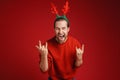 Young man wearing Christmas deer horns screaming while gesturing Royalty Free Stock Photo