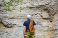 Young man wearing in climbing equipment with rope standing in front of a stone rock Royalty Free Stock Photo