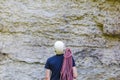 Young man wearing in climbing equipment with rope standing in front of a stone rock Royalty Free Stock Photo