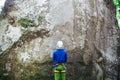 Young man wearing in climbing equipment with rope standing in front of a stone rock Royalty Free Stock Photo
